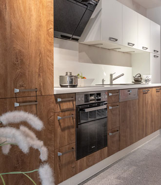 Moderne Küche mit weißen Hängeschränken und dunklen Holztüren